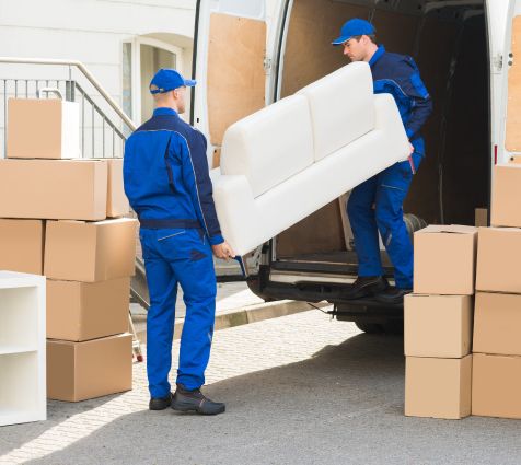 Umzugshelfer entladen Möbel aus einem Lieferwagen